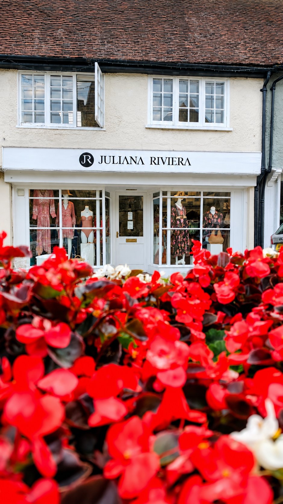 Juliana Riviera boutique on Red Lion Street in Midhurst, with red flowers in the foreground
